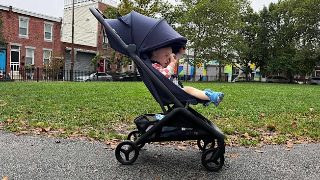 Profile view of a baby in a Bugaboo Butterfly Stroller with the canopy drawn over the child's head.