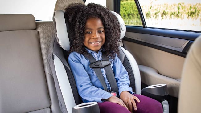 A 4 year old in a harnessed booster seat.