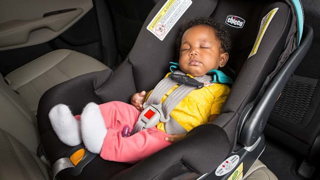 A newborn in rear-facing infant car seat.