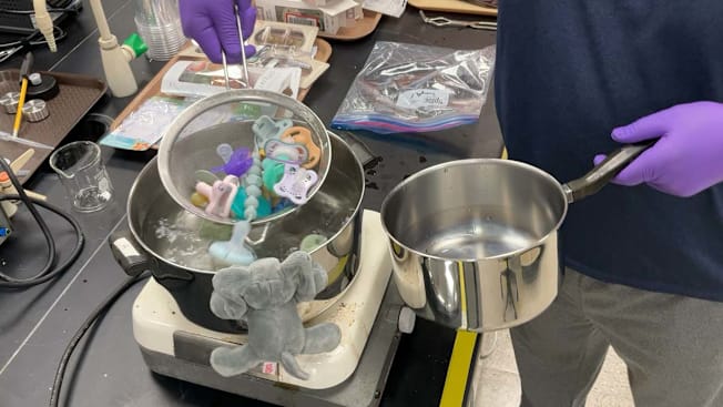 A tester at Consumer Reports conducting water retention tests to pacifiers in a lab.