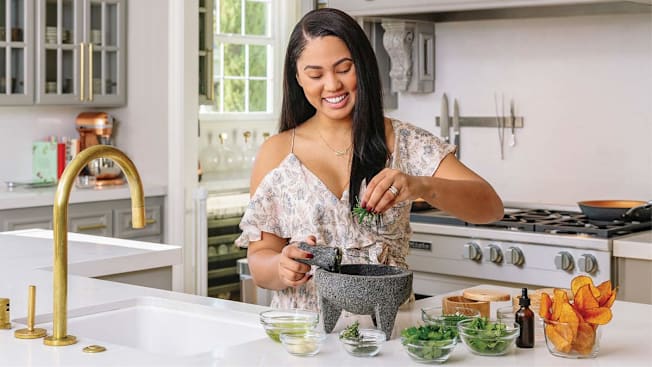Ayesha Curry making a guacamole in a kitchen
