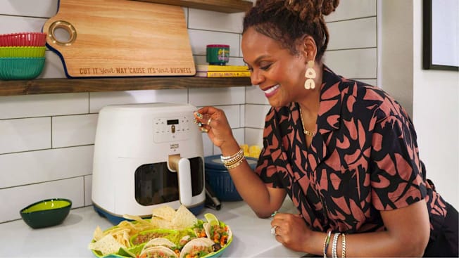 Tabitha Brown net to her brand's air fryer and looking at the tacos she just prepared