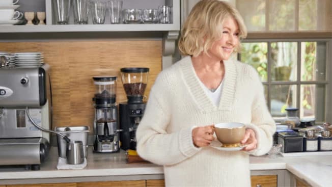 Martha Stewart in her kitchen enjoying a cup of coffee.