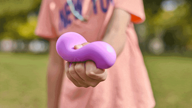 Kid is squeezing a purple sensory gel ball