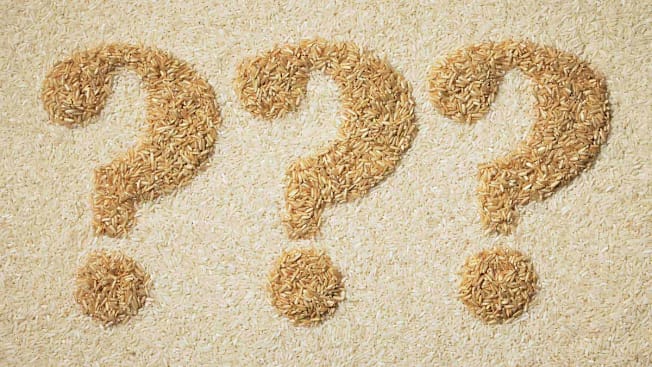 3 question mark symbols made of brown rice on a background of white rice.