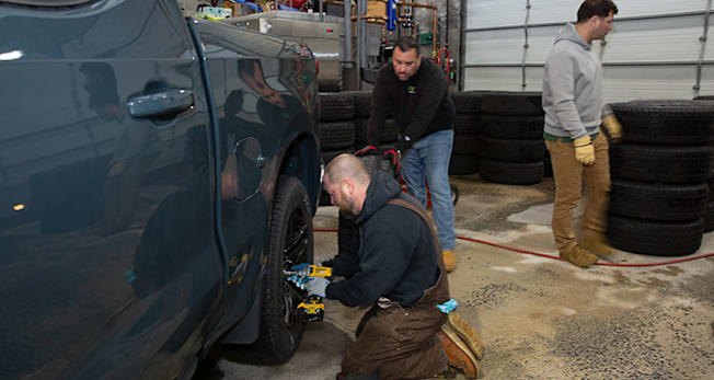 Mike Jascot, Julian Barrera, and  Ryan Pszczolkowski working behind the scenes on the many tire changes necessary to conduct the ice testing.
