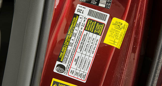 A car door placard showing the correct tire pressure.