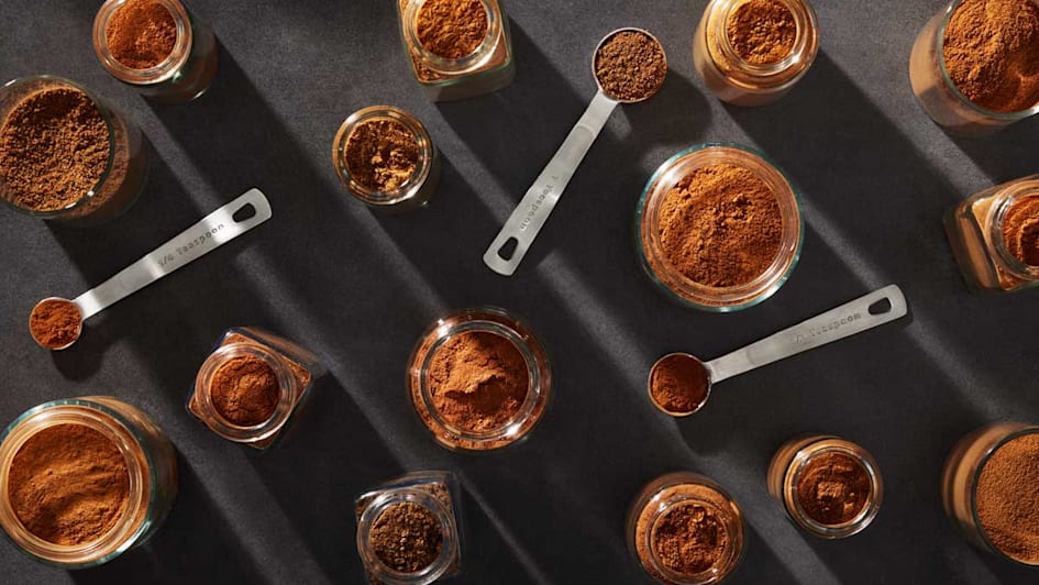 overhead view of various teaspoons and open jar filled with cinnamon