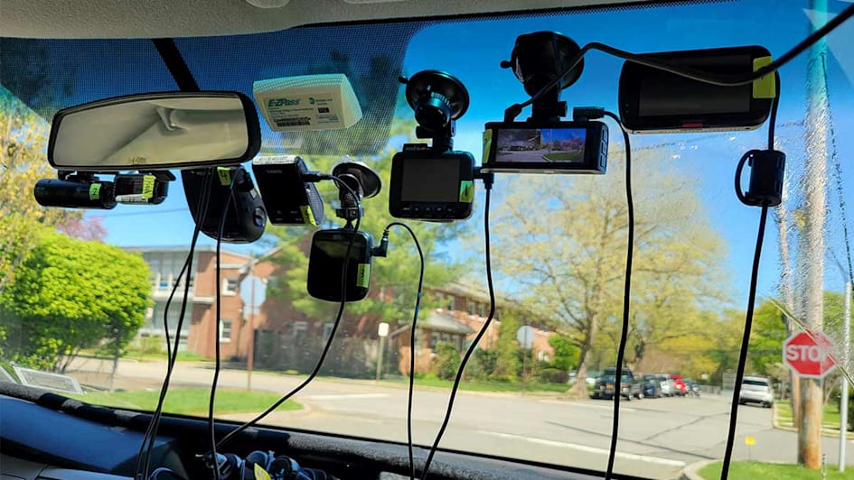 Numerous dashcams suctioned to the inside of a car's windshield.