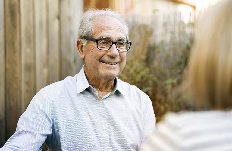 An older man smiling. 
