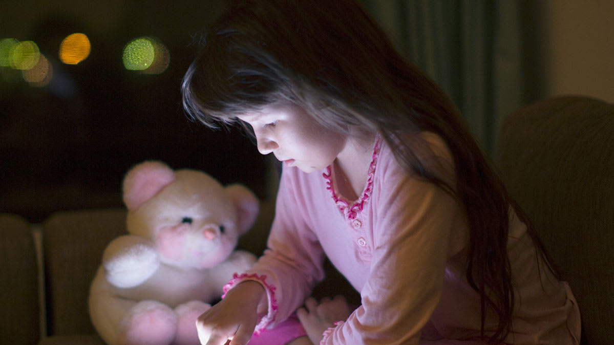 Connected toys being played with by a girl with a teddy bear visible. Such toys can have privacy risks.