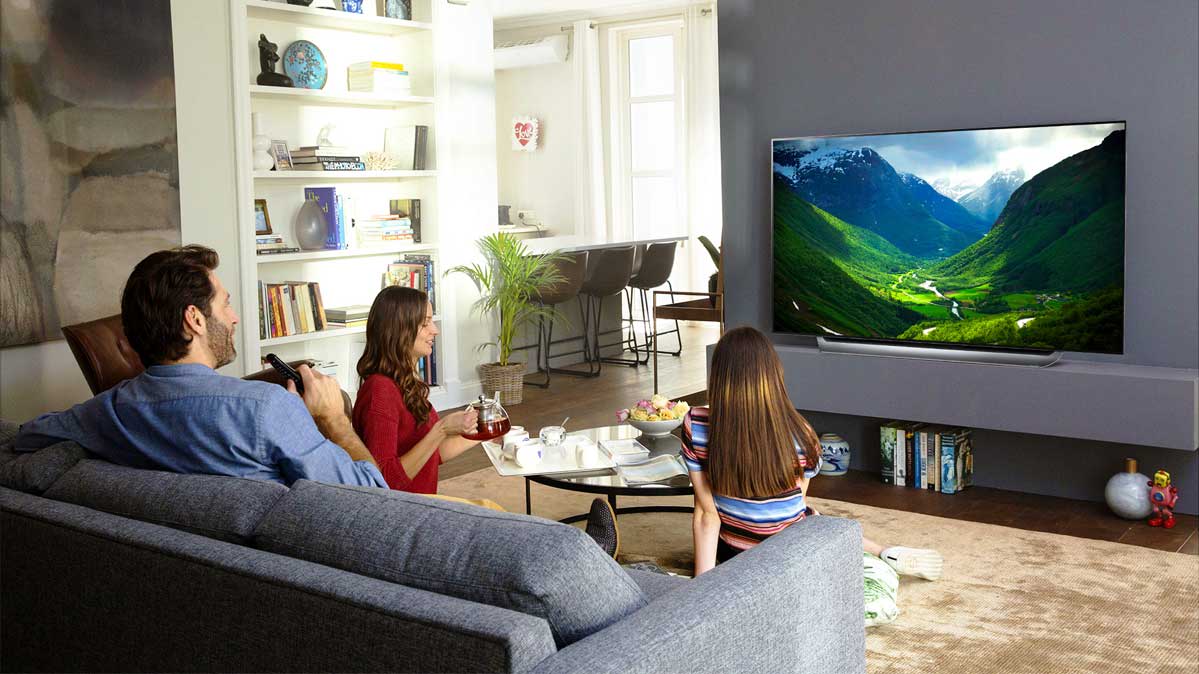 Family sitting in a living room watching TV.