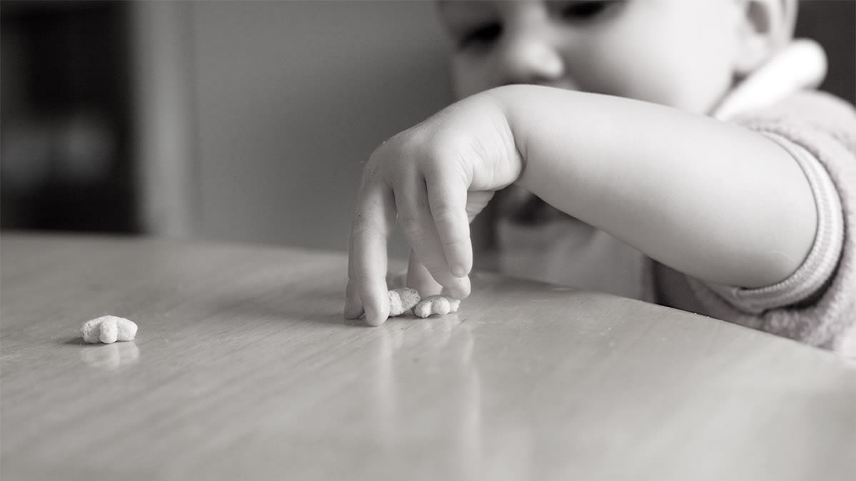 A toddler reaching for a snack food. Consumer Reports has found heavy metals in baby foods. 