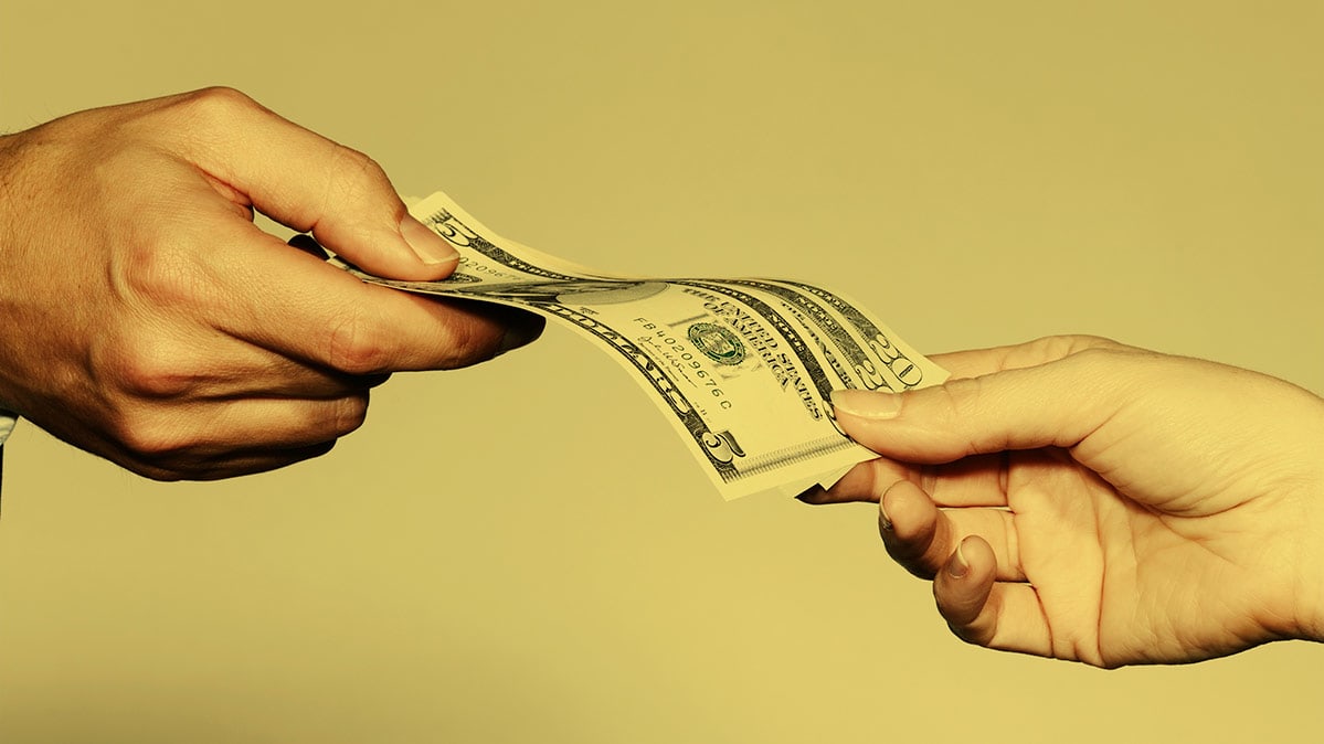 A person handing money to another person