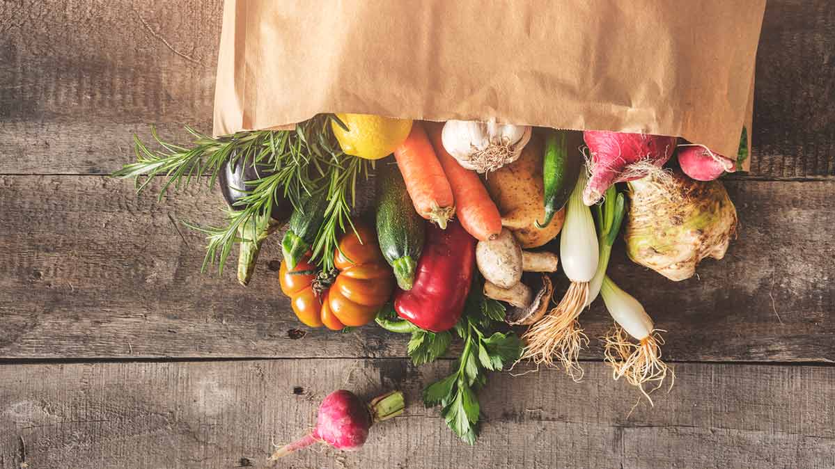 A grocery store bag filled with fresh produce