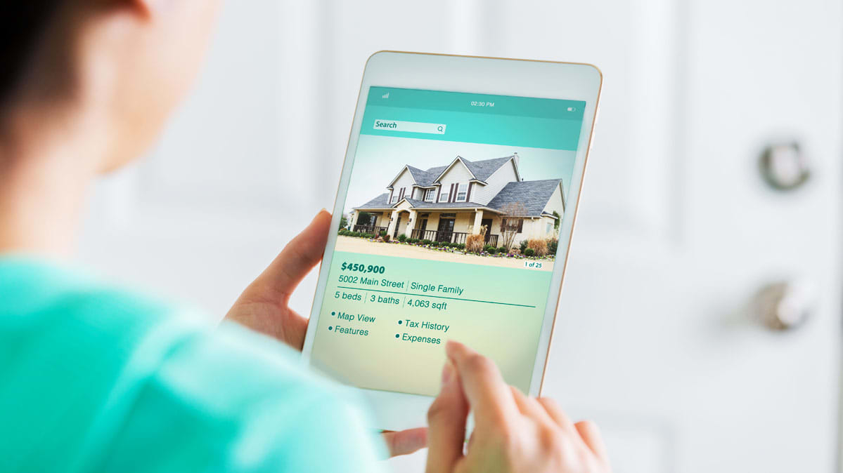 5 Tips For Selling Your Home Without An Agent Consumer Reports - a person reading an ad for a for sale by owner home