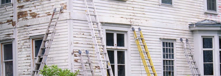 Paint peeling from the exterior of an older house.