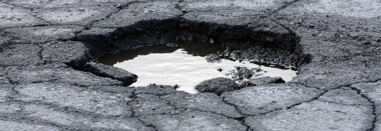 Photo of a pothole in a road that could do some major damage to a vehicle.