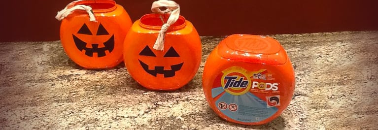 Laundry pod containers made into jack-o-lantern buckets.