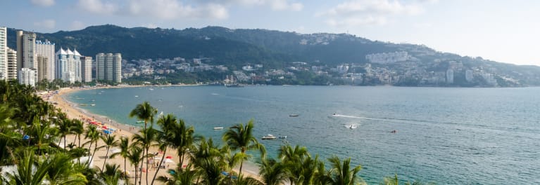 A view of a beach and apartment buildings, perhaps a resort.